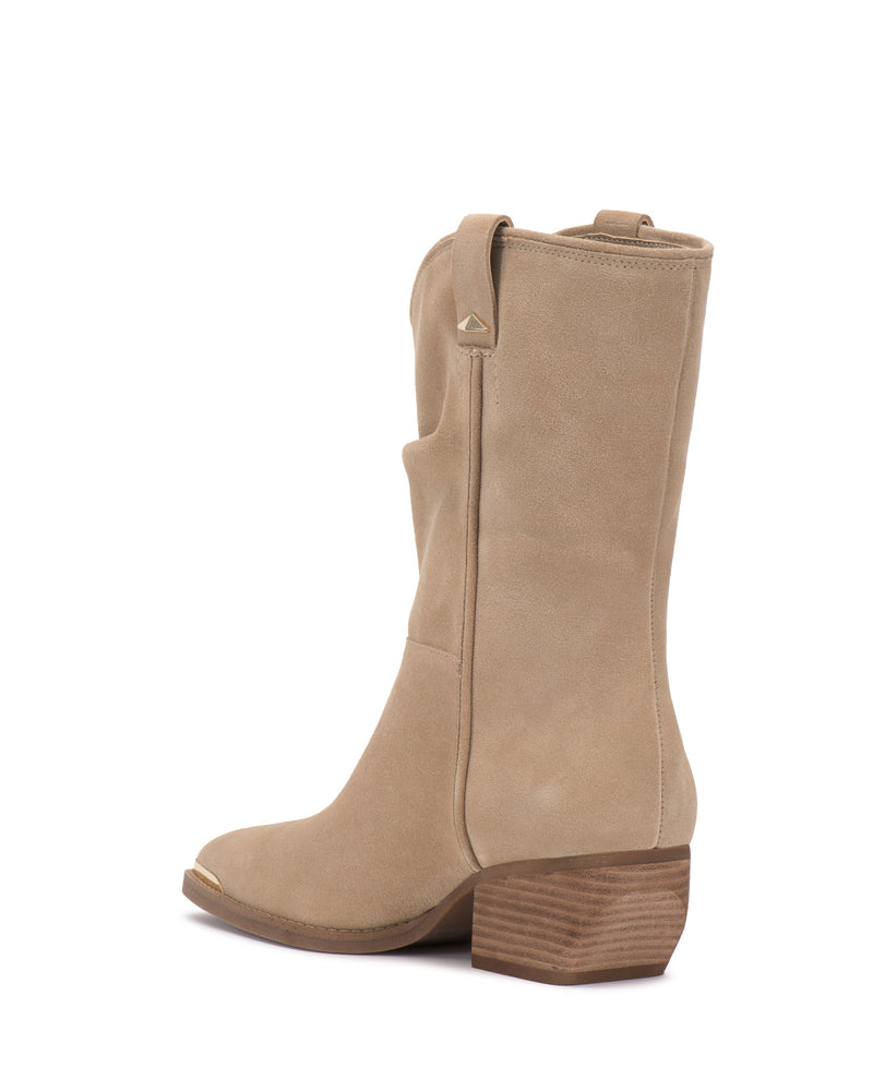 The Vince Camuto Pezzra Western Bootie features tan suede, a low stacked wooden heel, side pull tabs, pointed toe, and visible side stitching. This slouchy bootie is displayed against a white background.