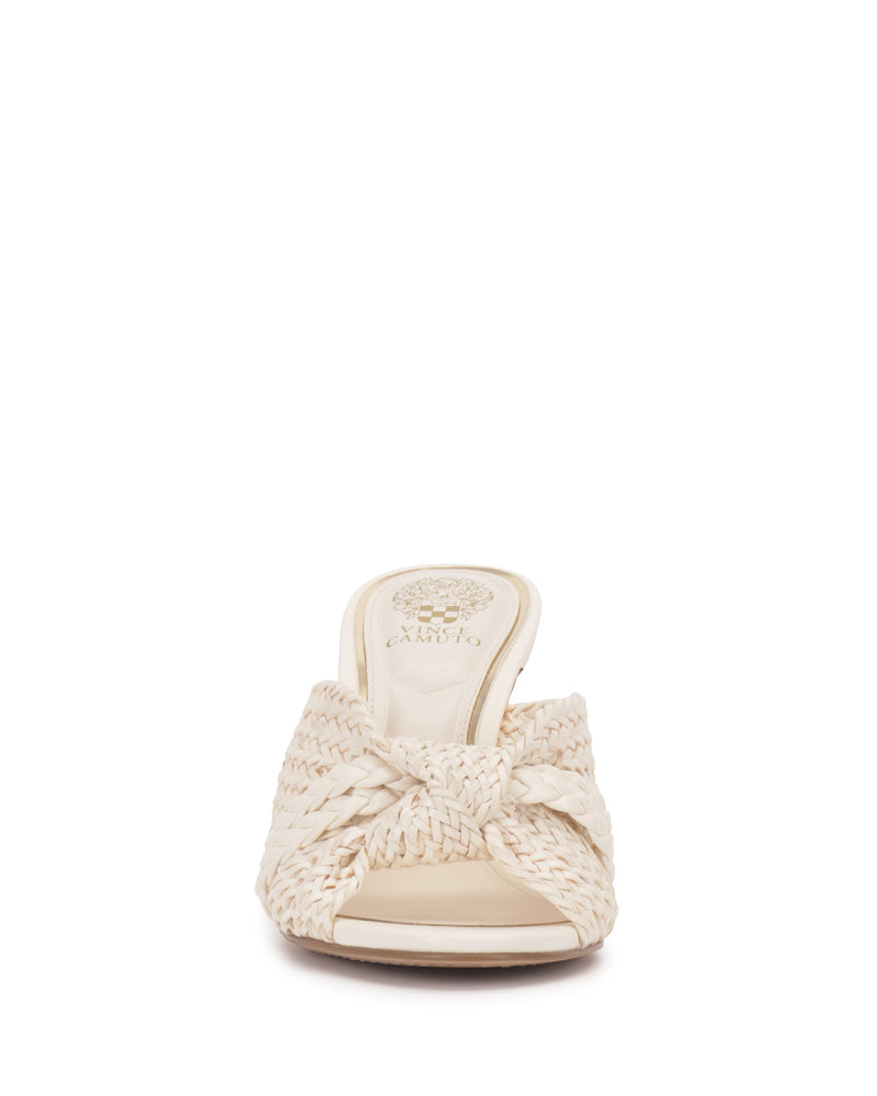 Front view of the Pheya Mule by Vince Camuto, a cream-colored heeled slip-on sandal with an open toe, woven design, knotted detail on top, and the brand logo on the insole.