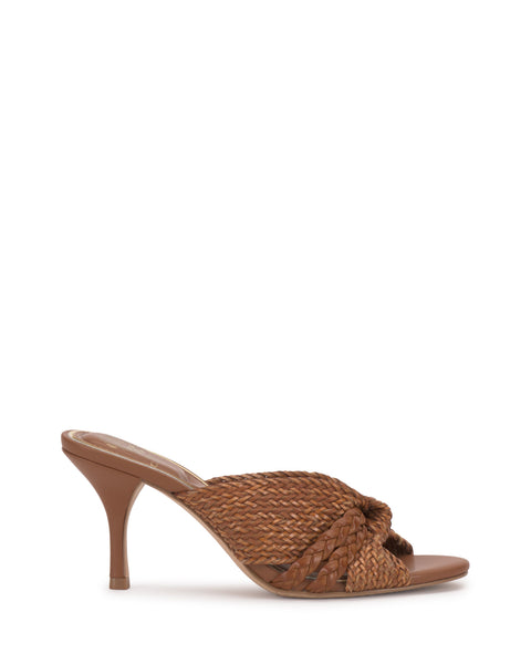 The Vince Camuto Pheya Mule is a brown heeled sandal with a woven design and twisted knotted detail on the front strap, displayed against a plain white background.
