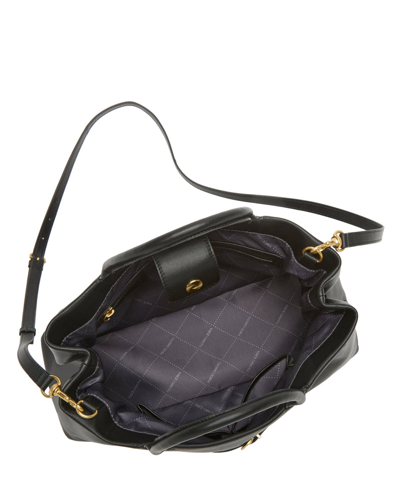 The Vince Camuto Rilah Satchel Bag is a black leather handbag with a long strap, shown from above with the top open to display its quilted fabric interior, zippered pocket, and snap-closure pocket.