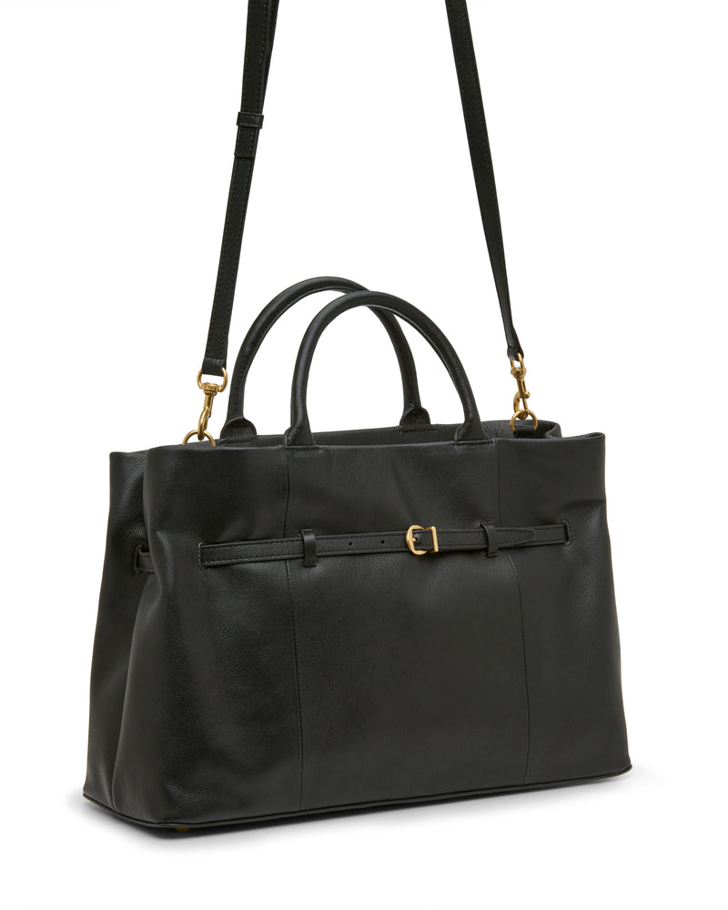 The Rilah Satchel Bag by Vince Camuto is a black leather handbag with short handles, a long adjustable shoulder strap, and a belt-like detail with a small gold buckle on the front.