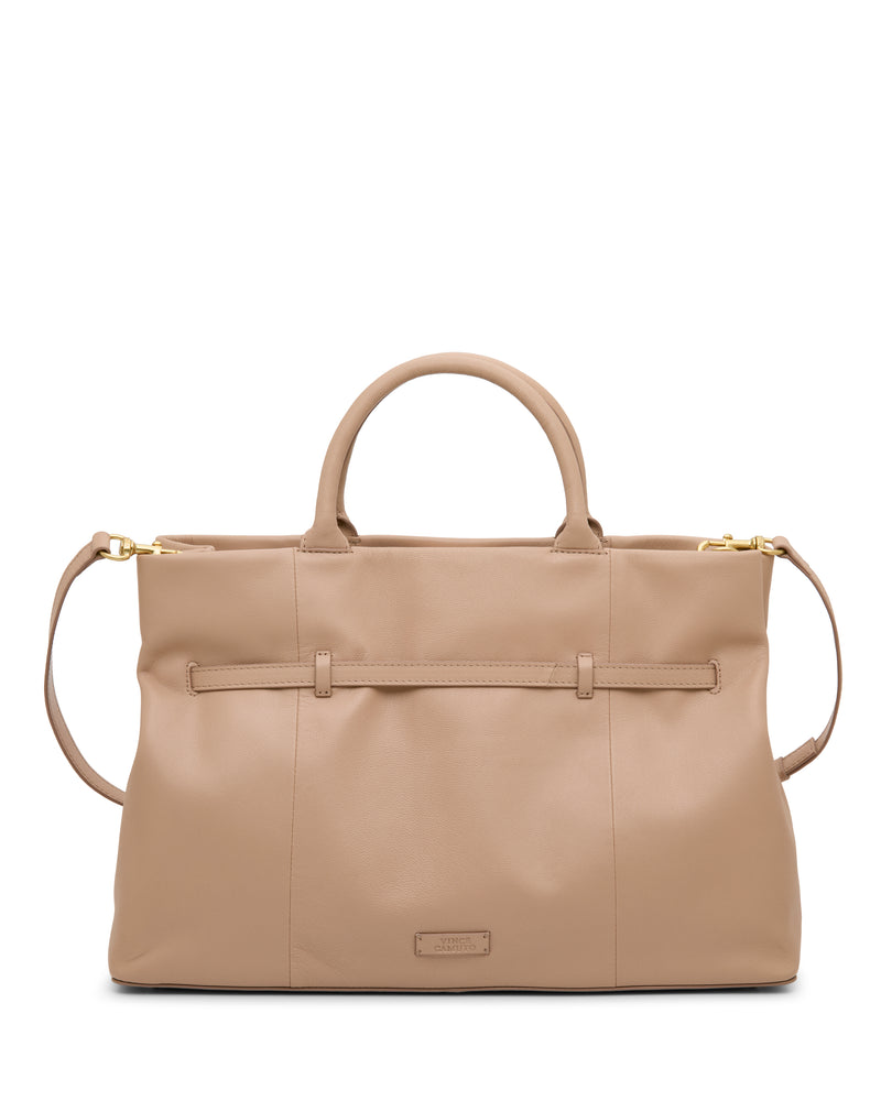 The Vince Camuto Rilah Satchel Bag is a large beige leather handbag with rounded handles, a detachable shoulder strap, and gold hardware. Featuring a minimal, elegant design, it has a subtle brand tag on the front.