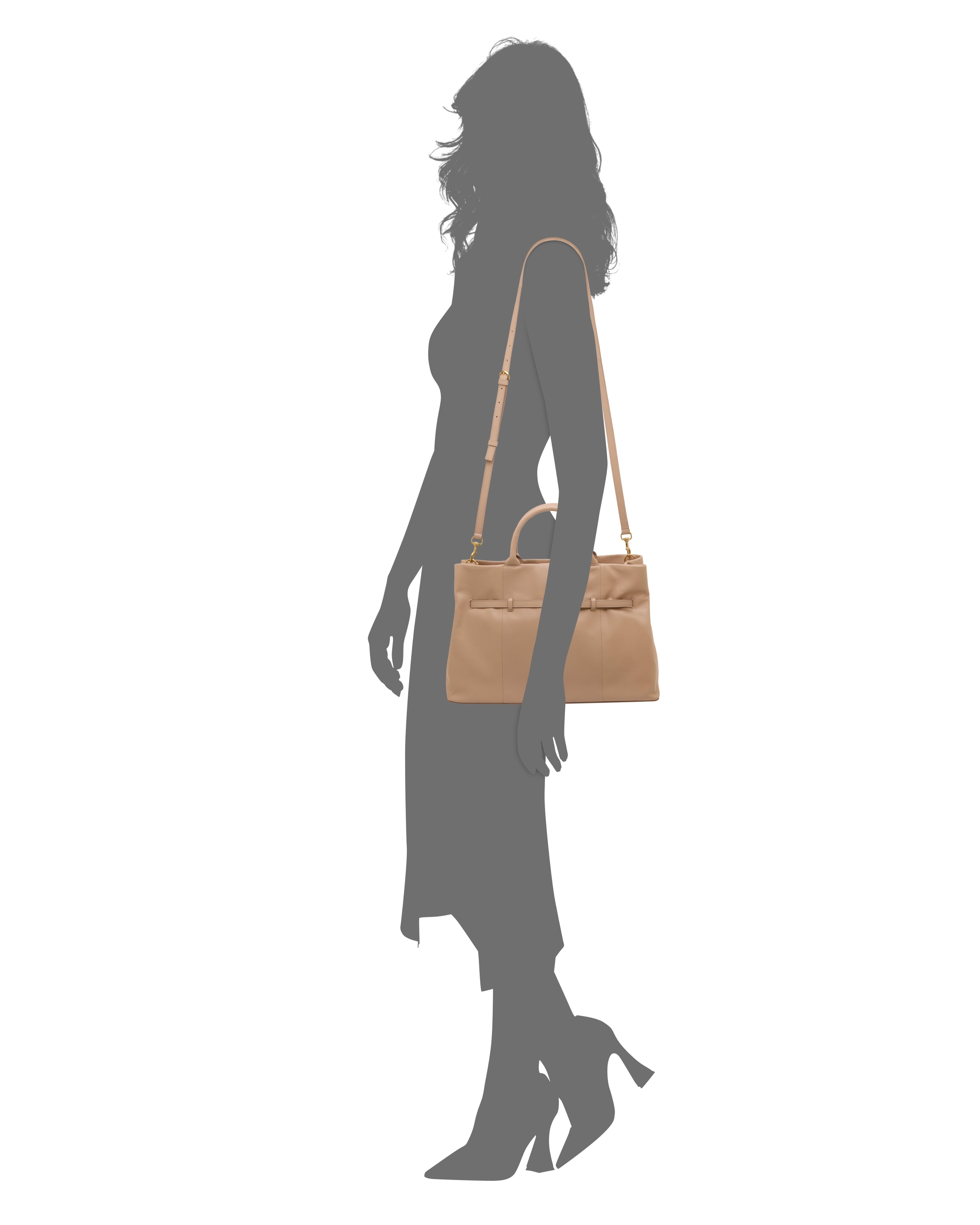 Silhouette of a woman in profile, wearing heeled shoes and a midi dress, carrying the Vince Camuto Rilah Satchel Bag—a tan leather shoulder bag with a top handle and gold hardware.
