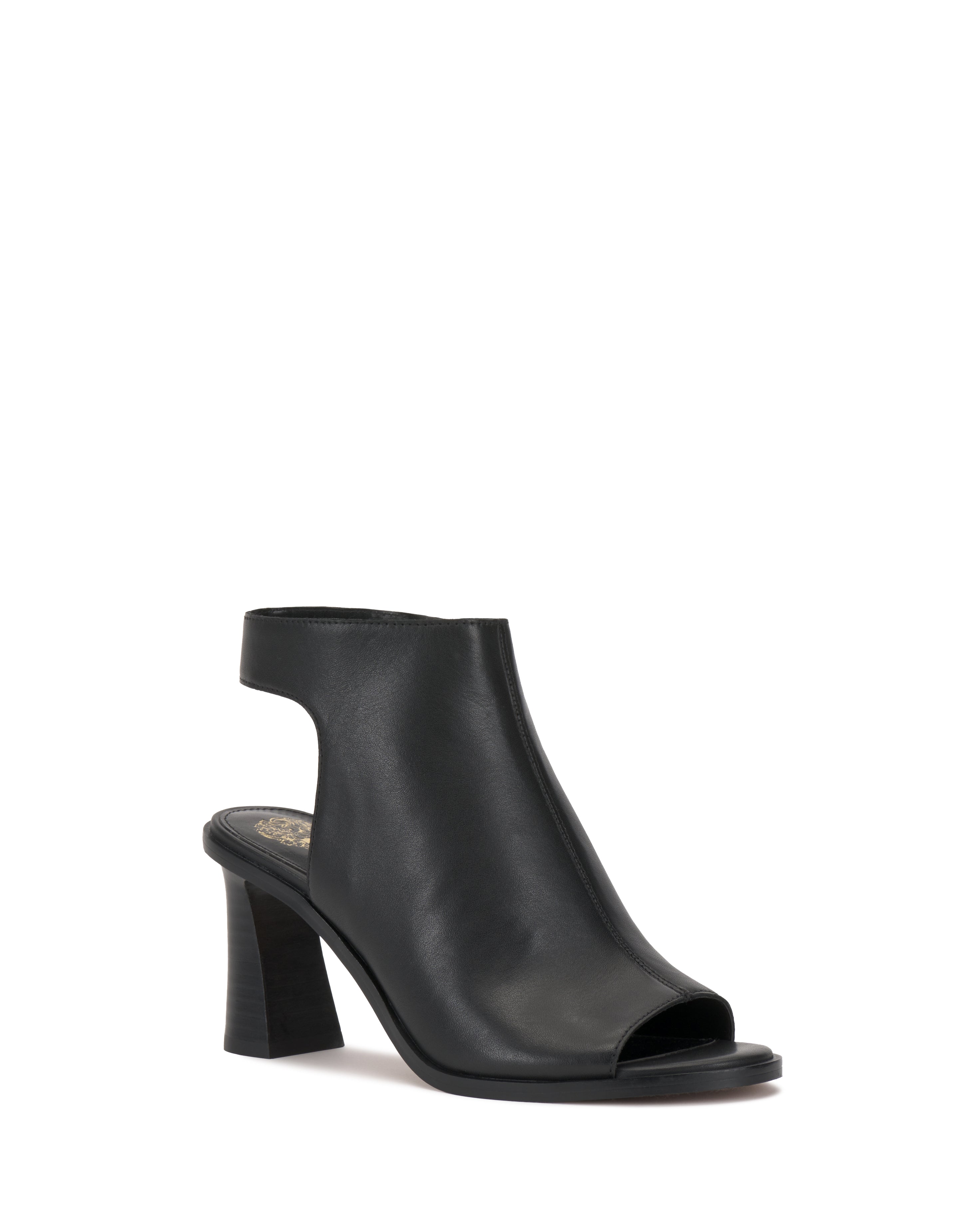 The Rimdia Sandal by Vince Camuto is a black slingback with an open toe, block heel, smooth leather finish, and cutout back. Its modern minimalist design features a closed upper and open heel for effortless style.