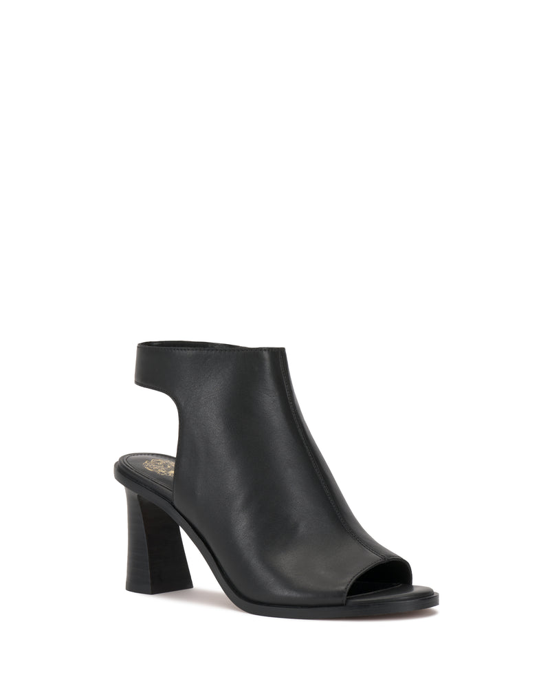 The Rimdia Sandal by Vince Camuto is a black slingback with an open toe, block heel, smooth leather finish, and cutout back. Its modern minimalist design features a closed upper and open heel for effortless style.