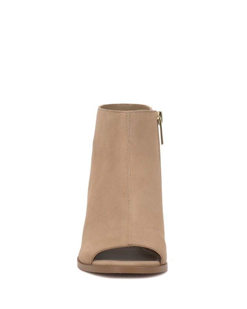 Front view of the Vince Camuto Rimdia Sandal, a beige suede peep toe bootie with a side zipper and flat sole, shown against a white background.
