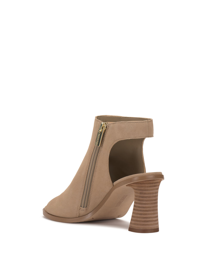 The Rimdia Sandal by Vince Camuto is a beige peep toe bootie with cut-out sides, zipper closure, and a wide stacked wooden block heel, shown from the back left angle.