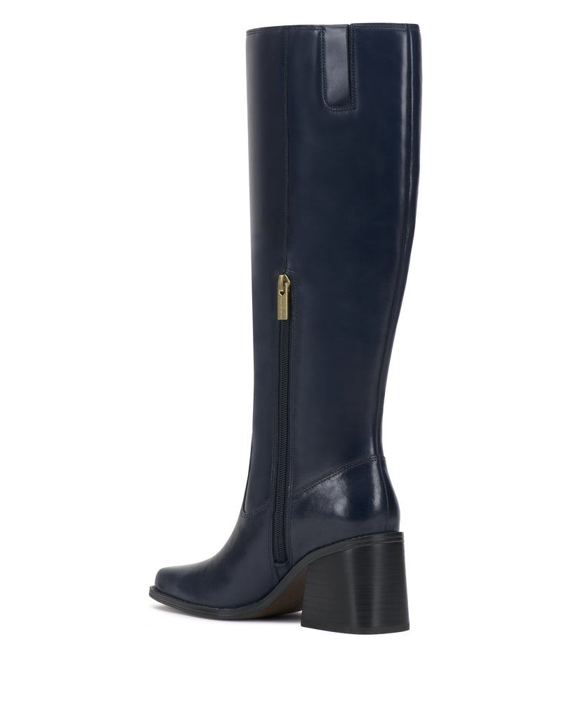 The Sangeti Wide Calf Boot by Vince Camuto is a navy blue, knee-high leather boot designed with a block heel, side zipper, and a subtly pointed toe. Shown in side profile against a white background, this style is available in multiple calf widths for a customized fit.