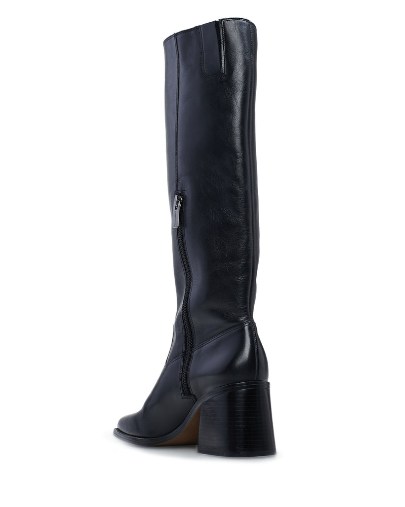 The Vince Camuto Sangeti Extra Wide Calf Boot is a black knee-high leather boot with a side zipper, rounded toe, and chunky mid-height block heel, shown from a rear side angle on a white background. Ideal for stylish wide-calf comfort.