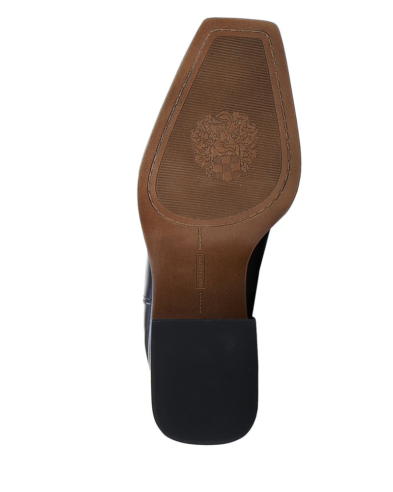 The image shows the sole of the Sangeti Extra Wide Calf Boot by Vince Camuto. It features a black square toe, light brown decorative crest and stitching, and a block-shaped heel for a sleek, formal look.
