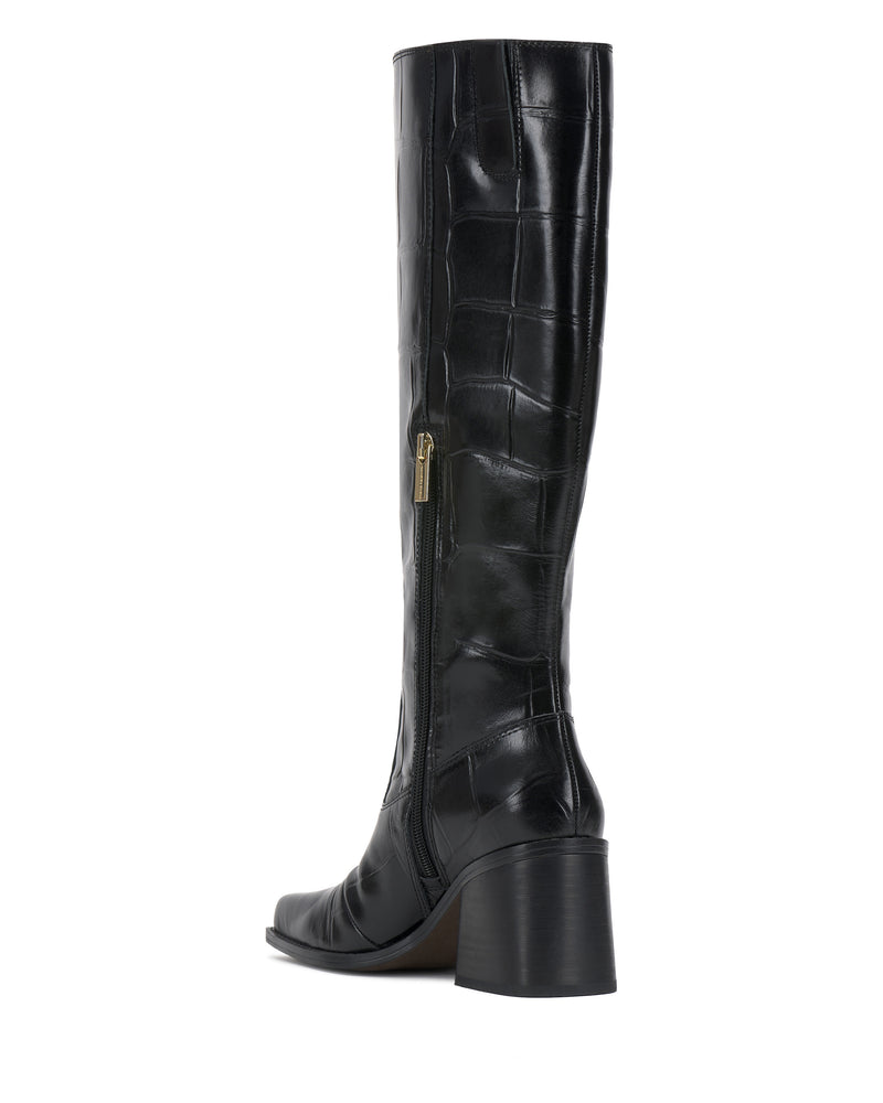 The Vince Camuto Sangeti Boot is a black, knee-high boot featuring a block heel, side zipper, and glossy faux crocodile texture, displayed at an angled back view.