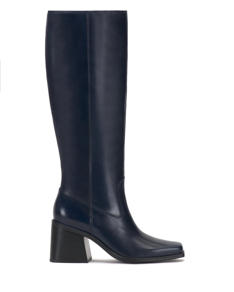 The Sangeti Boot by Vince Camuto is shown in profile on a white background. This tall, navy blue leather knee-high boot features a square toe and a chunky, medium-height block heel, and is available in multiple calf widths.