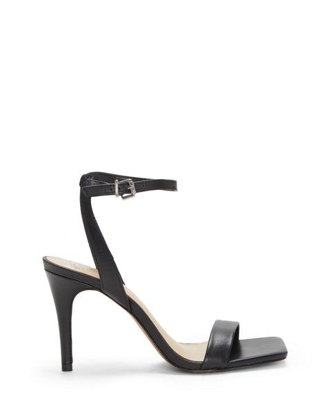 The Vince Camuto Saprenda Sandal features a black open-toe design with a single front strap, thin ankle strap with buckle, and a slim high heel, all showcased on a white background.