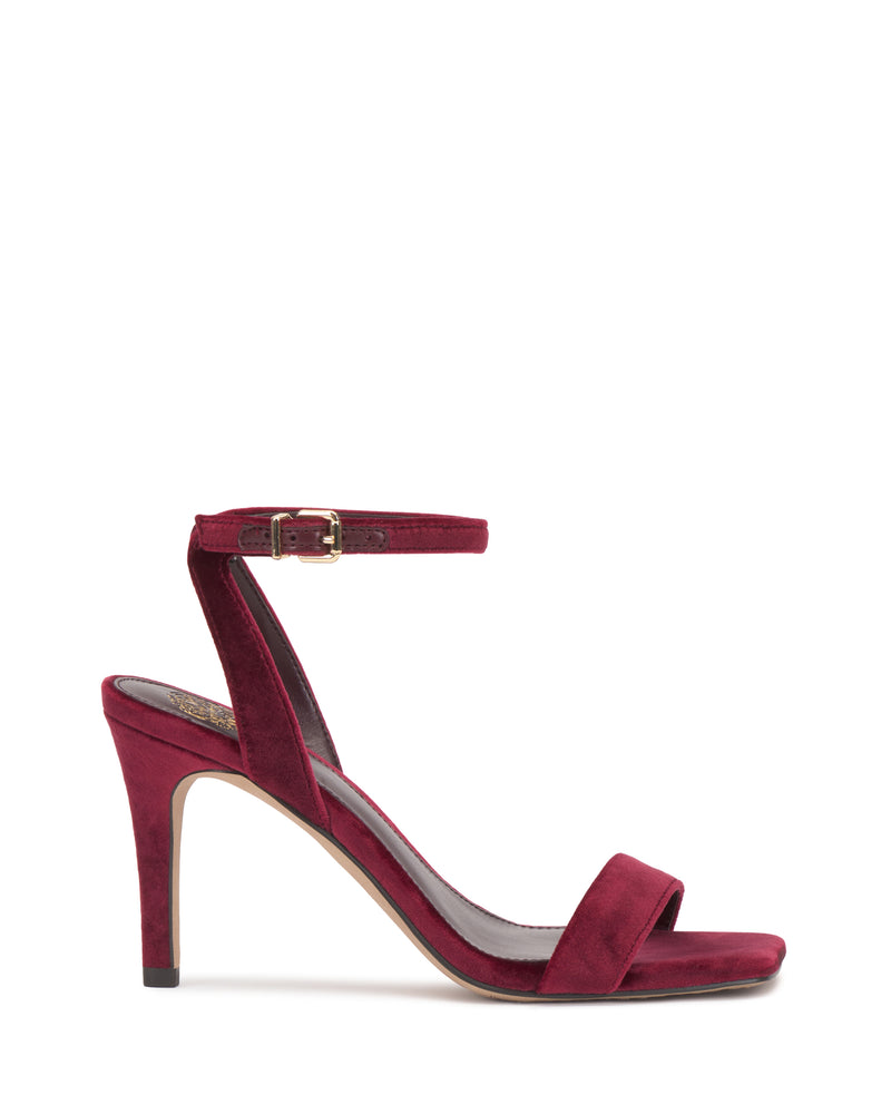 The Saprenda Sandal by Vince Camuto is displayed on a white background, featuring a single burgundy dress sandal with an open toe, ankle strap and buckle, and a slim heel.