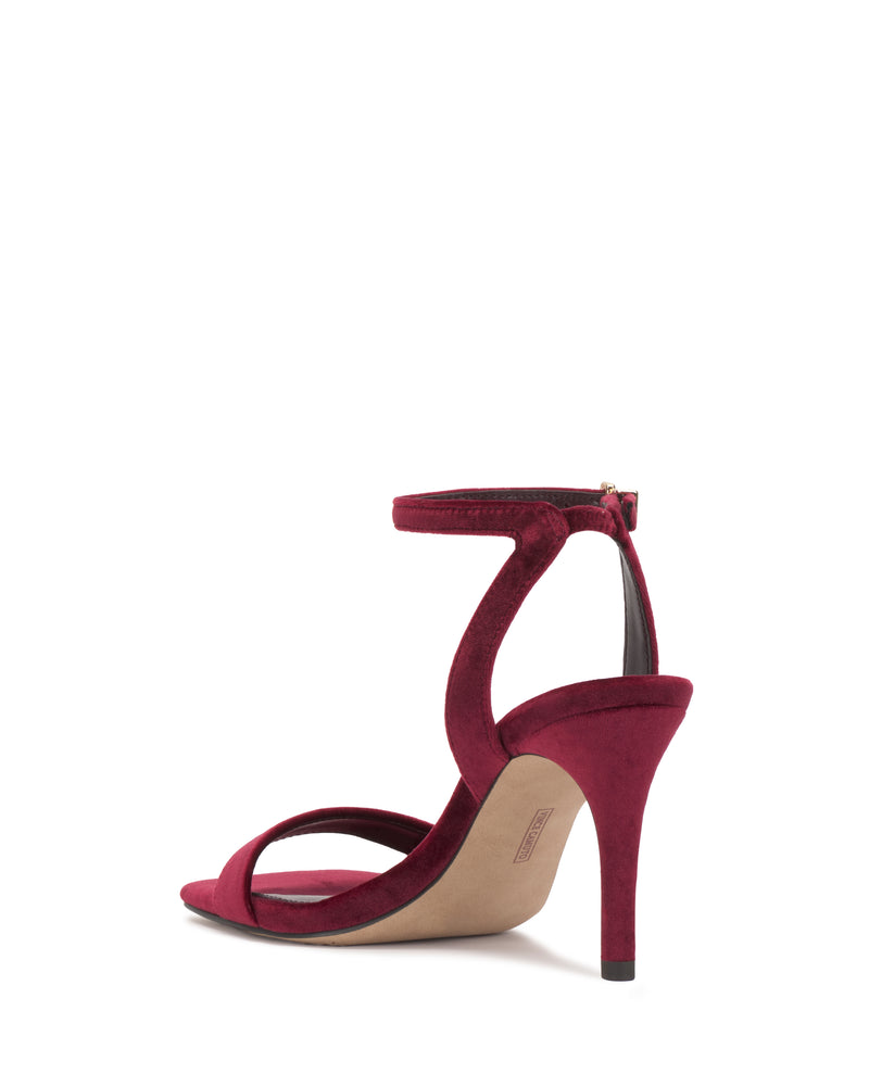 A red velvet Saprenda Sandal by Vince Camuto, featuring a sleek ankle strap and open toe, is shown from the back right angle against a white background.