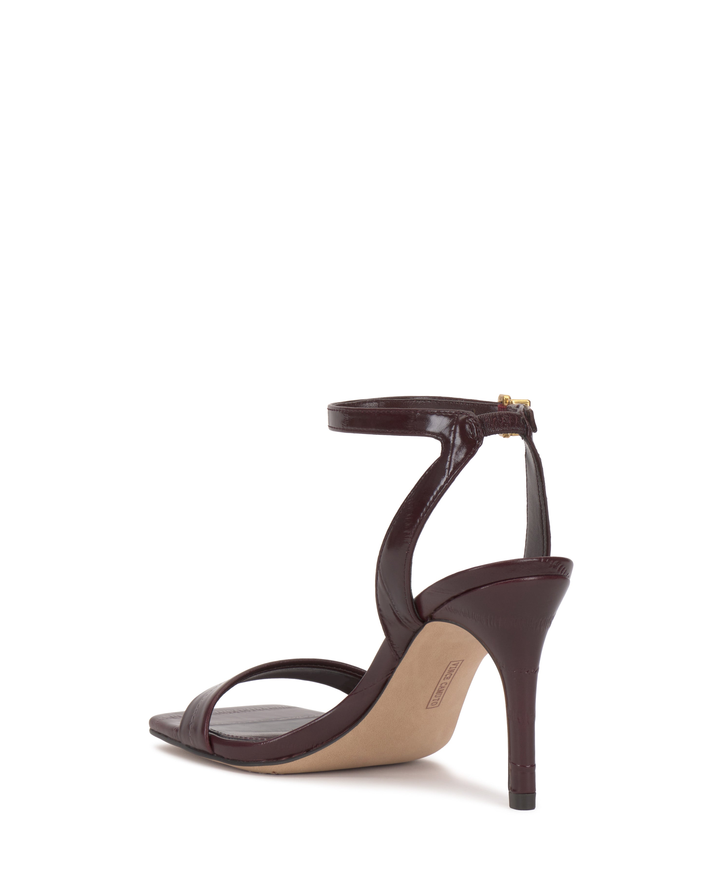 The Vince Camuto Saprenda Sandal, a single maroon dress shoe with an open toe, ankle strap, and thin heel, is displayed from the back right angle against a white background.
