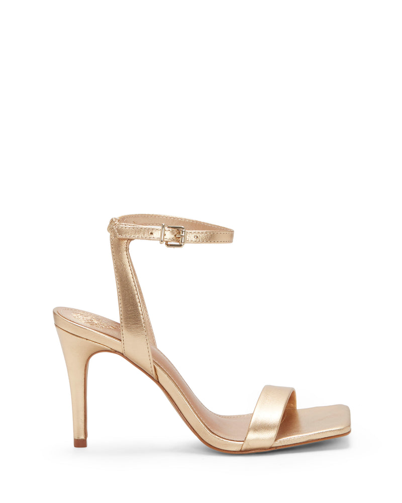 The Vince Camuto Saprenda Sandal is a gold metallic high-heeled shoe featuring an open toe, single toe strap, and ankle strap with a small buckle, displayed in profile on a white background.