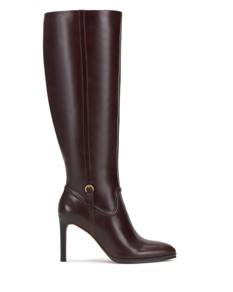A single Vince Camuto Sareya Knee High Boot crafted from dark brown leather, featuring a pointed toe and a gold buckle detail near the ankle, is displayed in profile on a white background. The boot boasts a sleek silhouette and is made from premium materials.