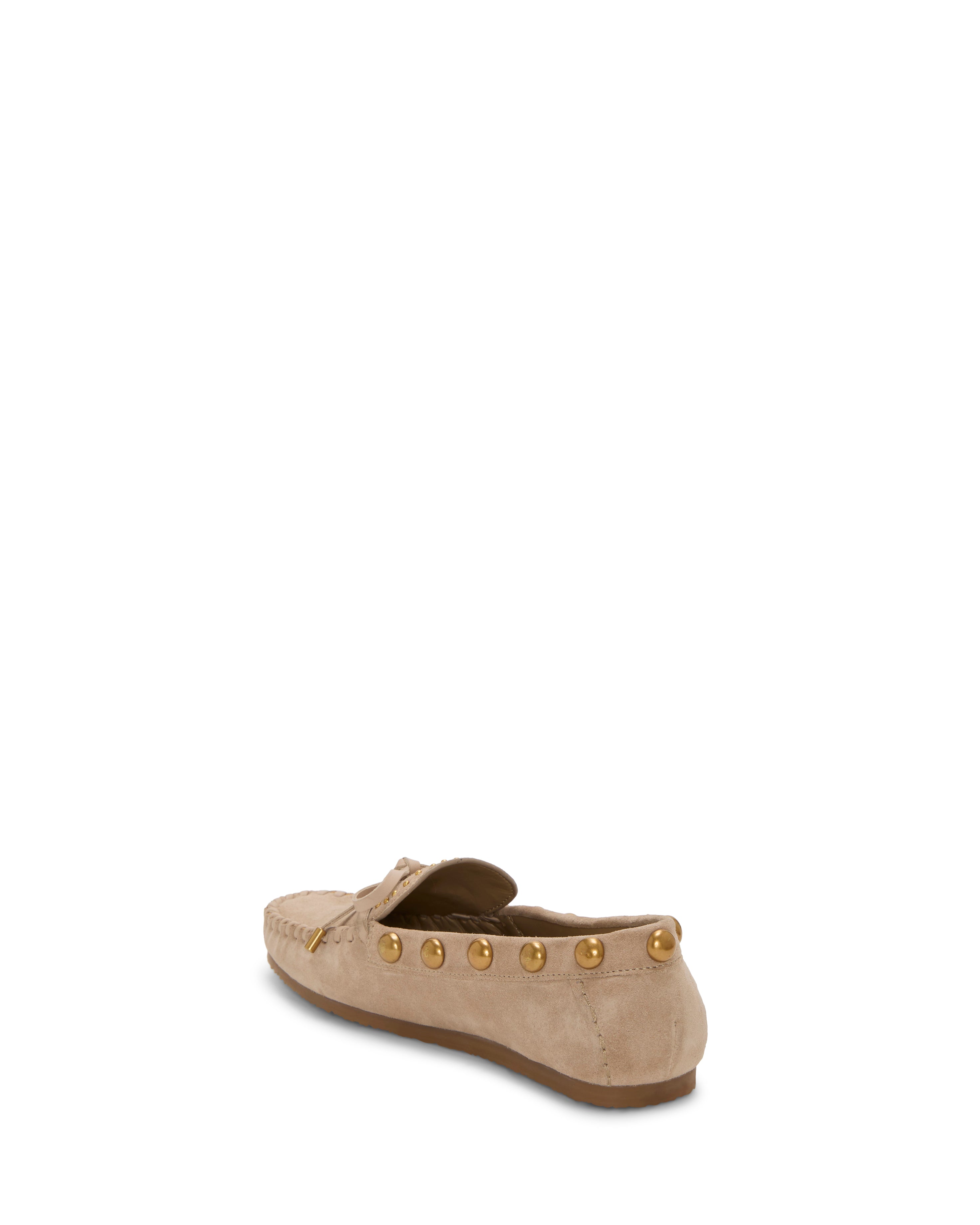 The Vince Camuto Sennett Studded Mocassin is a beige suede loafer featuring gold stud accents on the heel and side, shown from a rear-side angle against a white background.