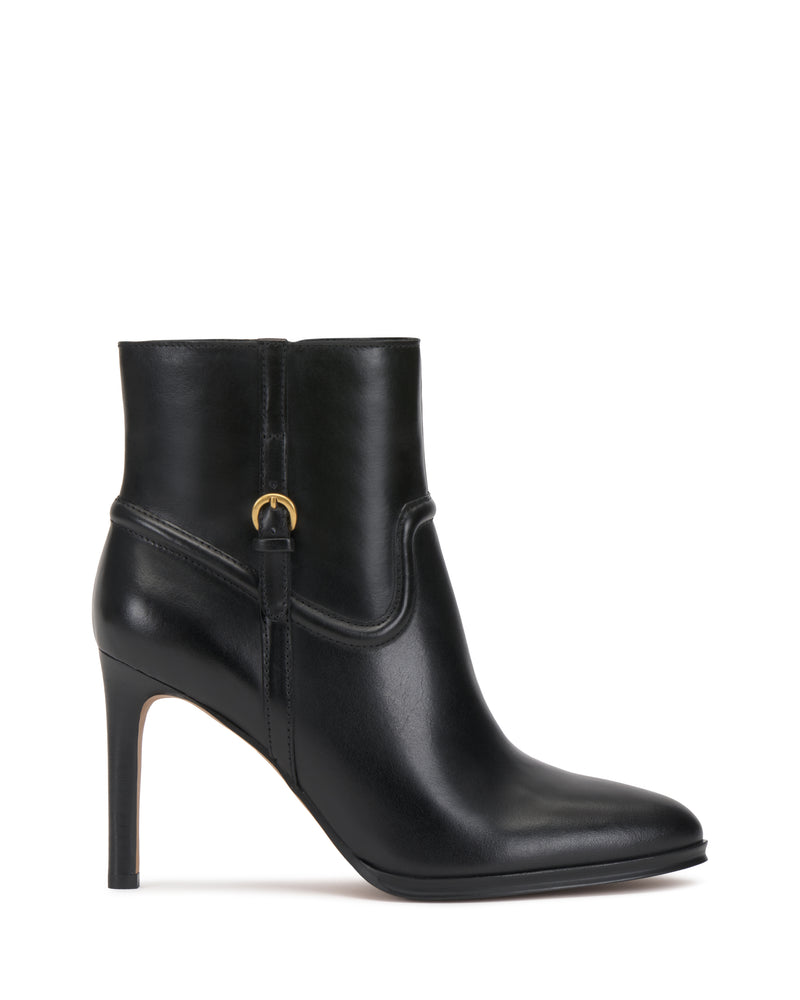 The Setily Bootie by Vince Camuto is a black leather ankle boot featuring a pointed toe, high stiletto heel, and a gold buckle accent on the side. The boot boasts a smooth finish and showcases a sleek, elegant design.