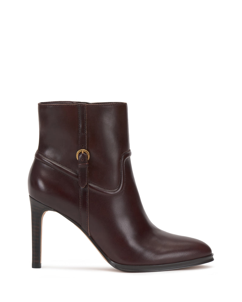 The Vince Camuto Setily Bootie is a dark brown leather ankle boot featuring a high stiletto heel, a side strap, and a small gold buckle, displayed in profile on a white background.