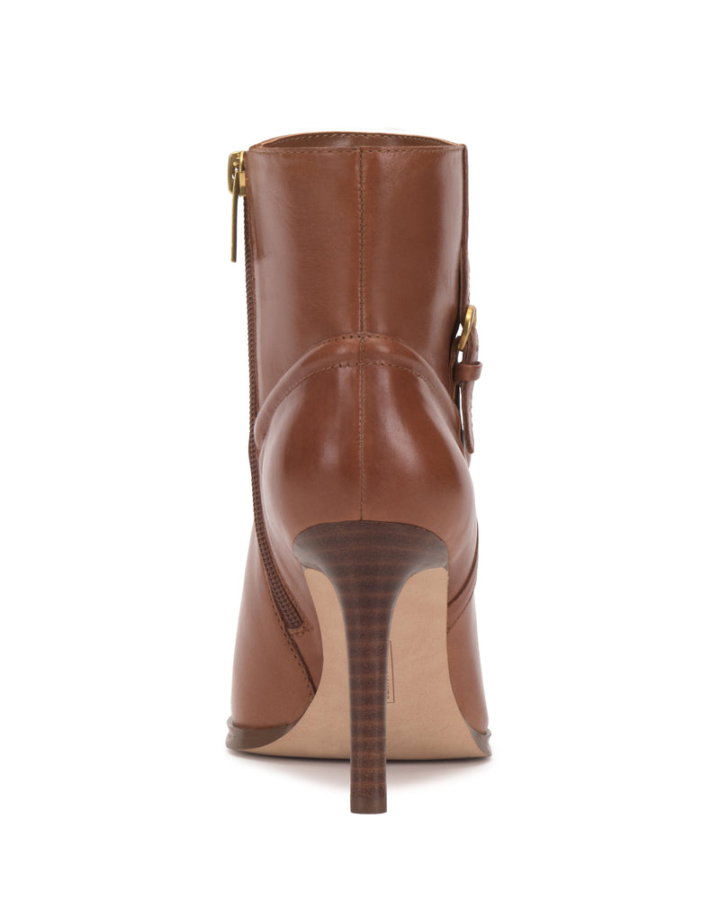 The Setily Bootie by Vince Camuto is a brown leather ankle boot with high heels, shown from the back and featuring gold zipper and buckle details on the side.