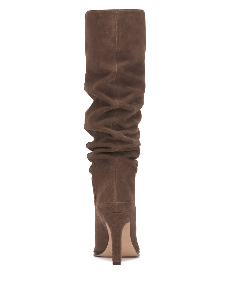 Back view of the Vince Camuto Sorina Wide Calf Knee High Boot in tall brown suede, featuring a slouchy silhouette, pointed toe, and high stiletto heel—an effortlessly chic addition to your collection of slouchy boots, shown against a white background.