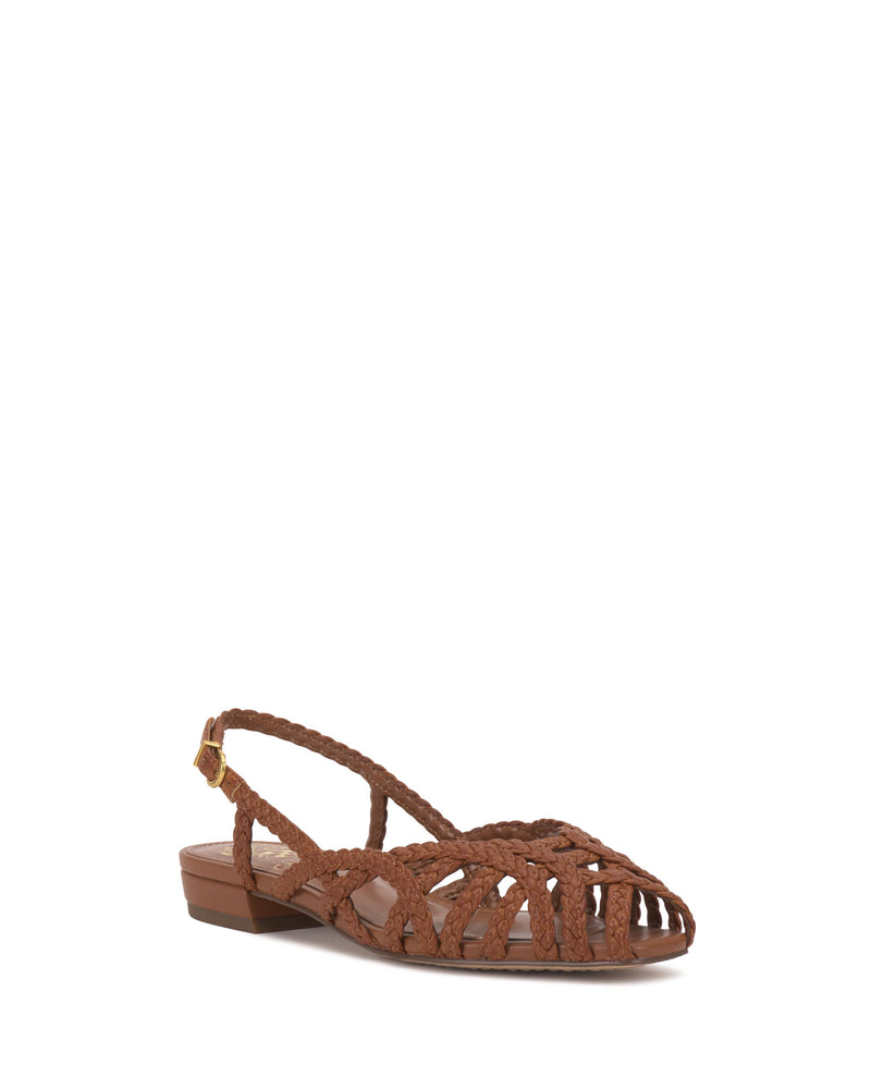 The Vince Camuto Stiorra Sandal displays a brown woven design with braided accents, low block heel, open toe, cut-outs, and an ankle strap with buckle, set against a white background.