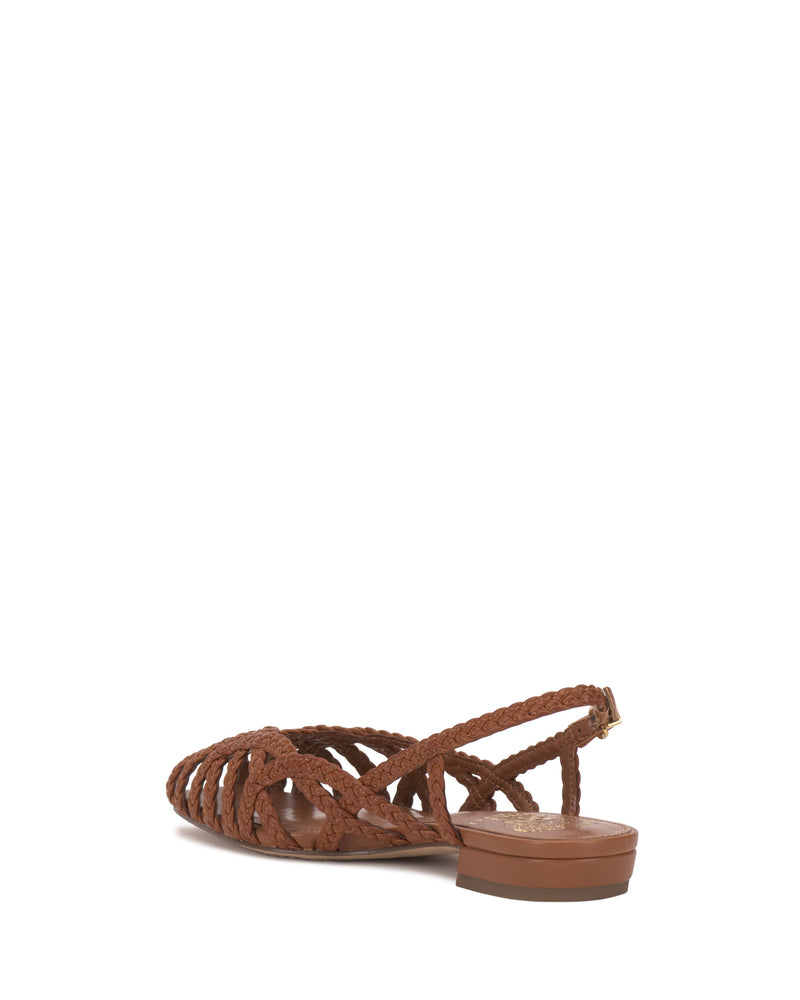 The Vince Camuto Stiorra Sandal showcases brown woven braids, a closed toe, low block heel, and ankle strap, seen from the back on a white background.