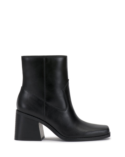 The Sybren Bootie by Vince Camuto features black leather, a chunky block heel, smooth finish, and side stitching detail, exuding modern sophistication against a white background.