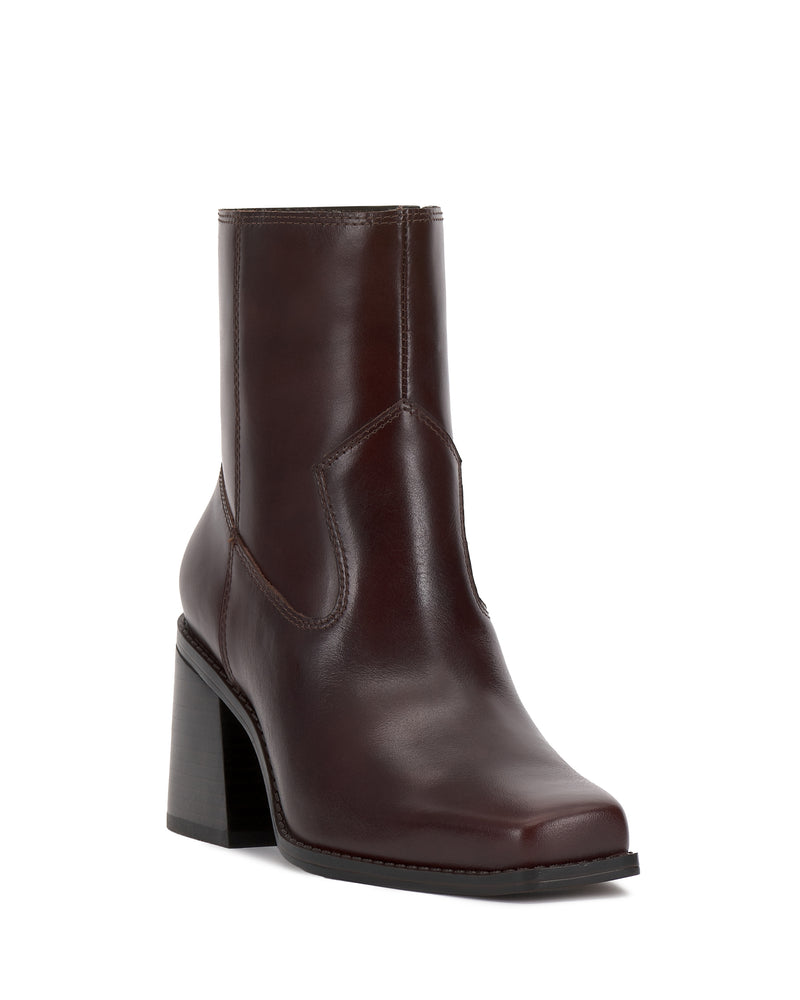 The Sybren Bootie by Vince Camuto is a brown leather ankle boot featuring a square toe and a chunky block heel, exuding modern sophistication against a white background.