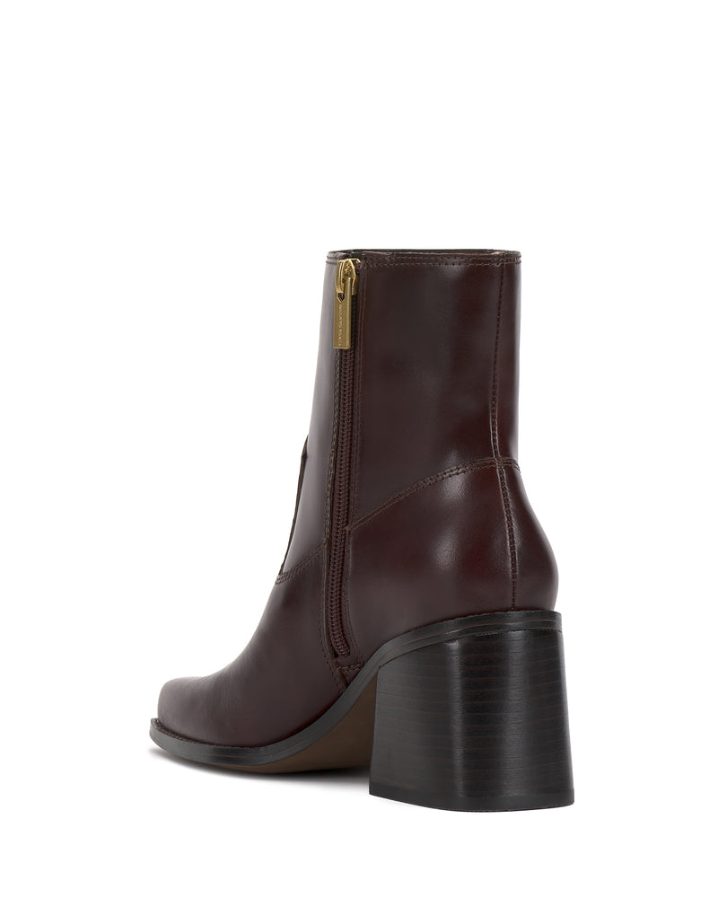 The Sybren Bootie by Vince Camuto, crafted in rich brown leather with a side zipper and chunky block heel, showcases modern sophistication—displayed from the back angle against a white background.