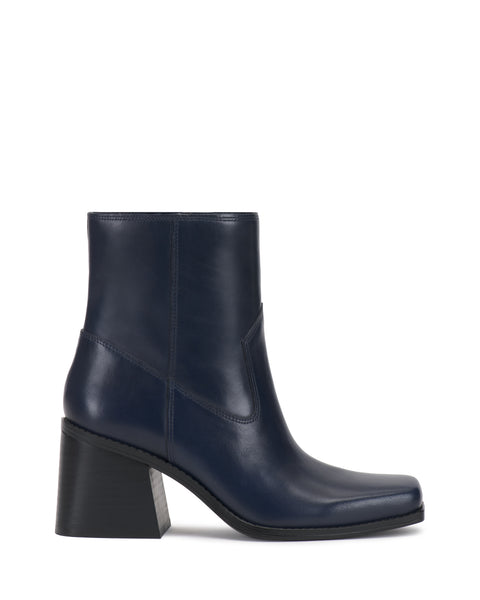 The Sybren Bootie by Vince Camuto is a navy blue leather ankle boot featuring a structured silhouette, medium-high chunky block heel, square toe, and visible stitch detailing.