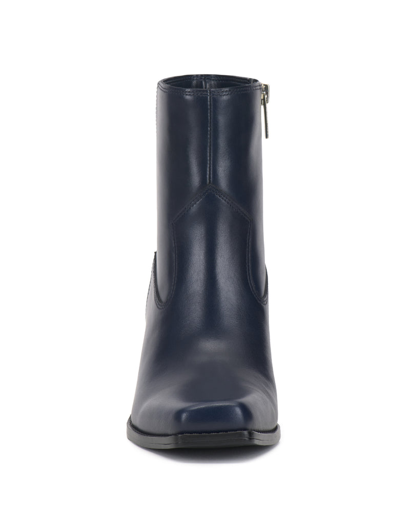 Front view of the Vince Camuto Sybren Bootie in dark blue, featuring a side zipper, smooth leather finish, and a small flat heel. This boot showcases a structured silhouette with minimal stitching and a slightly squared toe.