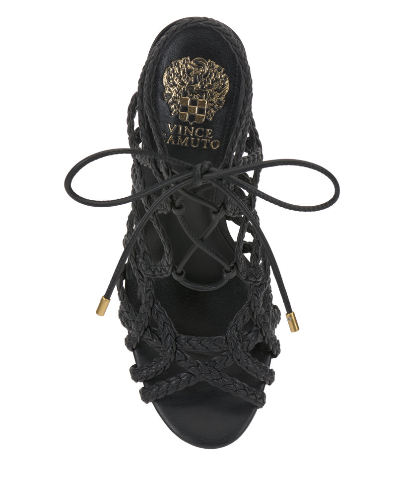 Top view of the Vince Camuto Tilly Sandal in black, showcasing braided straps, a lace-up design, and a gold logo detail on the insole.