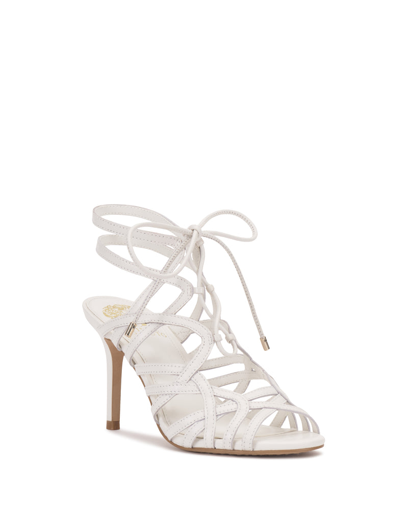 The Vince Camuto Tilly Sandal is a white, open-toe strappy sandal with a stiletto heel and lace-up ankle design, shown on a plain white background.