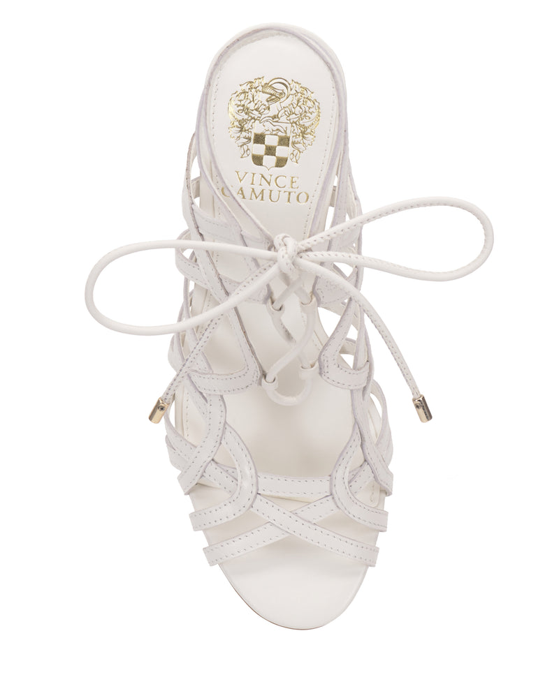 A top view of the Tilly Sandal by Vince Camuto shows a white strappy, lace-up sandal with intricate straps, gold aglets, an open toe, and a stylish stiletto heel.