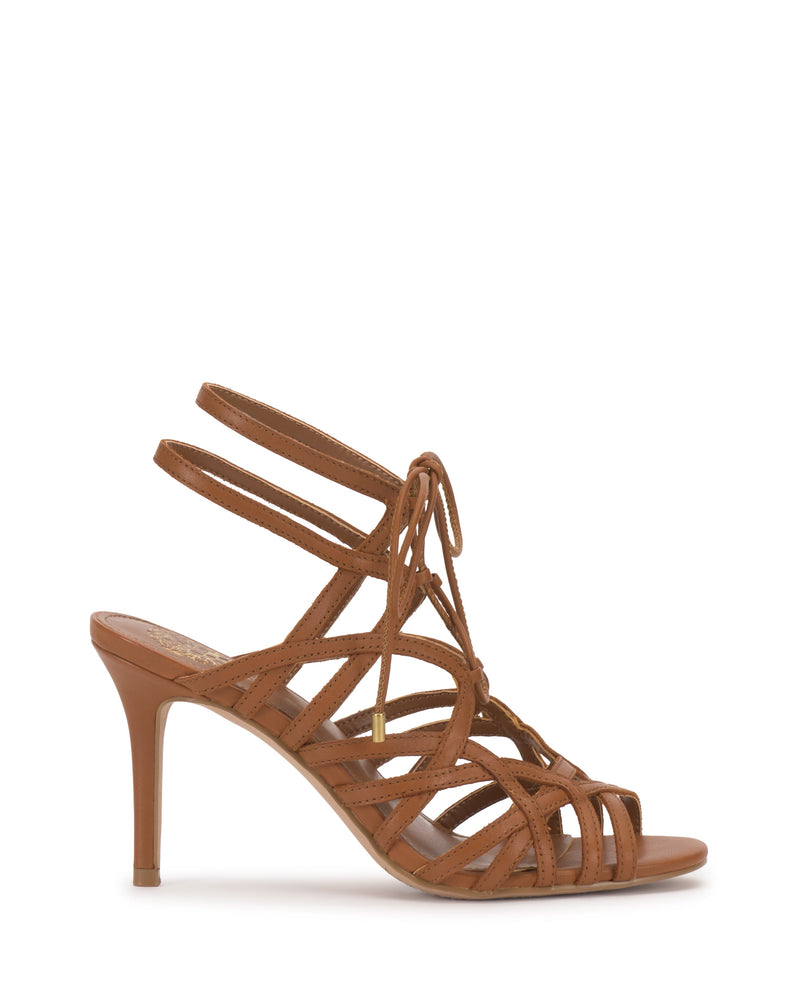 The Vince Camuto Tilly Sandal is a brown strappy stiletto with an open toe, double ankle straps, and an elegant lace-up design, shown in side profile on a white background.
