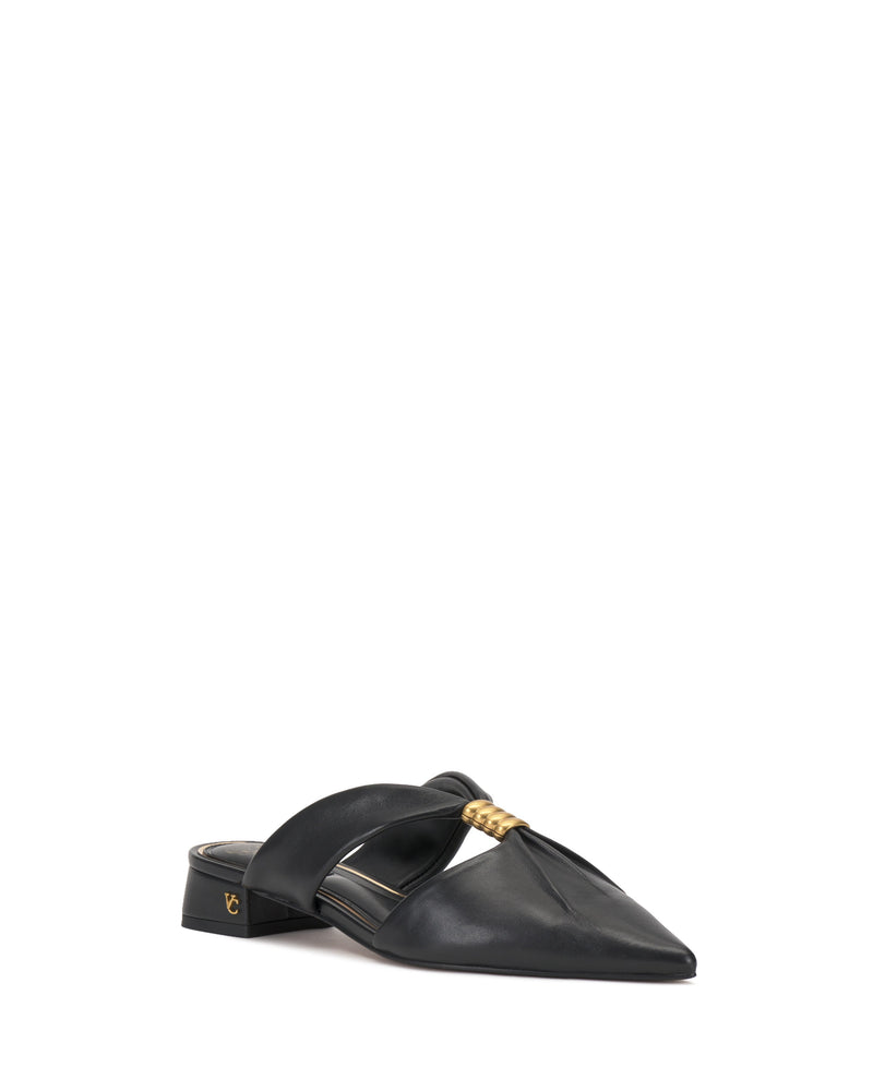 The Vince Camuto Vanika Mule showcases a black pointed toe, low block heel, wide crossing straps, and a gold decorative accent on the upper.