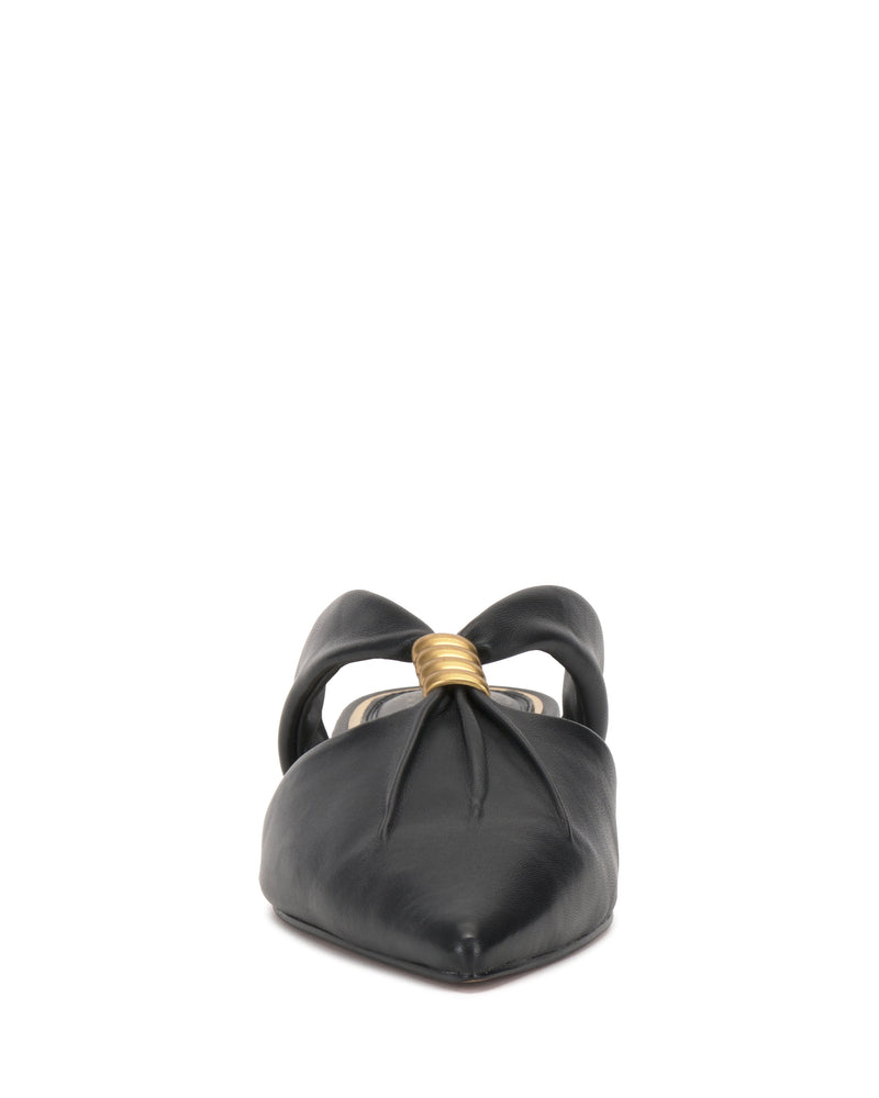Front view of the Vince Camuto Vanika Mule, a black pointed-toe flat with a twisted knot and gold metallic accent at the knot's center.