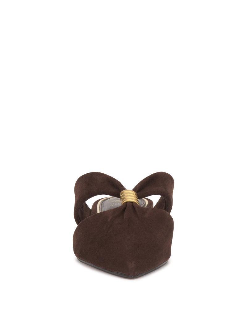 Front view of the Vince Camuto Vanika Mule—a brown suede shoe with a pointed toe, large bow and gold ring accent. This structured, elegant mule combines chic style with comfort, shown against a white background.