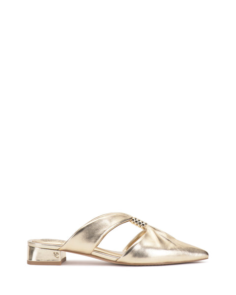 The Vince Camuto Vanika Mule showcases a gold metallic finish, low block heel, pointed toe, side cutouts, and a small embellishment near the instep.
