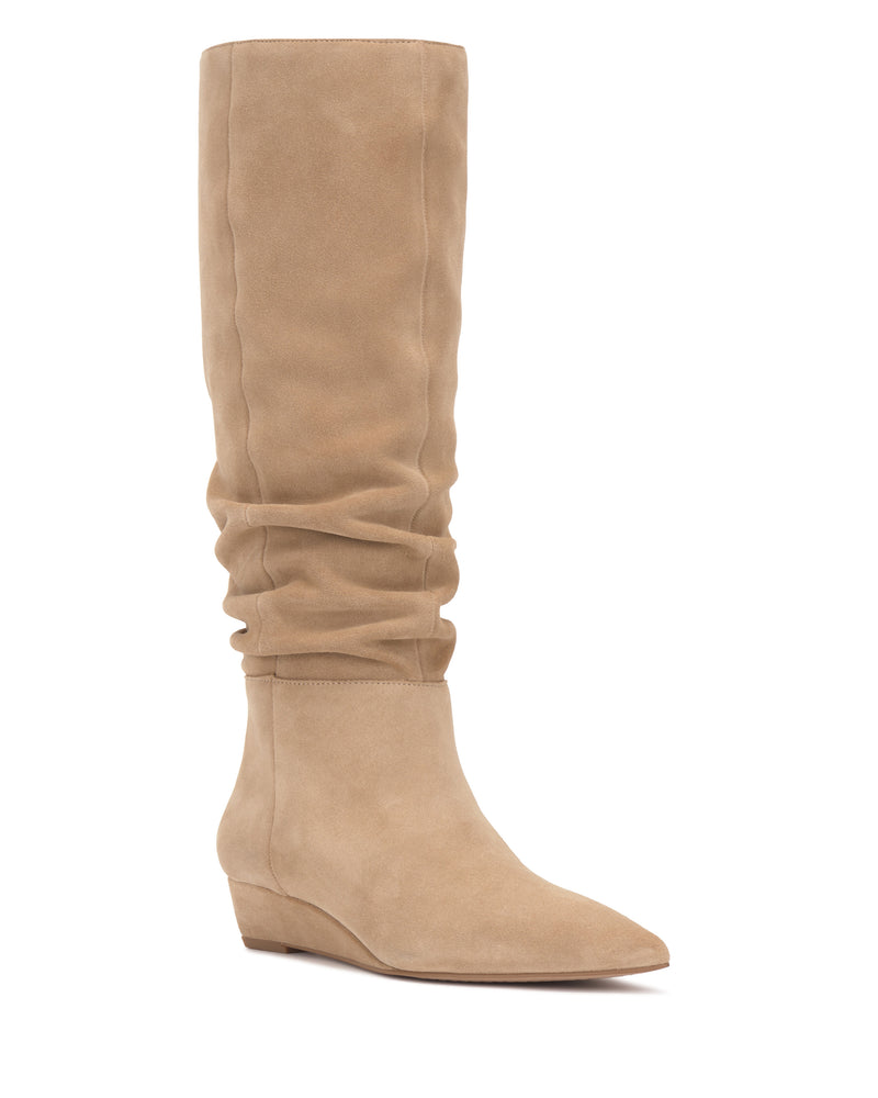 The Vanisa Narrow Calf Knee High Boot by Vince Camuto is shown on a white background, featuring tan suede, a slightly slouchy shaft, a pointed toe, and a low wedge heel.
