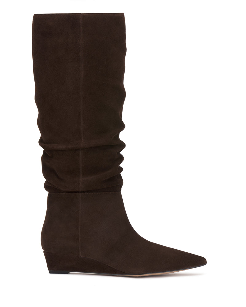 The Vanisa Wide Calf Knee High Boot by Vince Camuto is shown in profile against a white background, featuring dark brown suede, a pointed toe, low wedge heel, and a slightly slouched shaft.