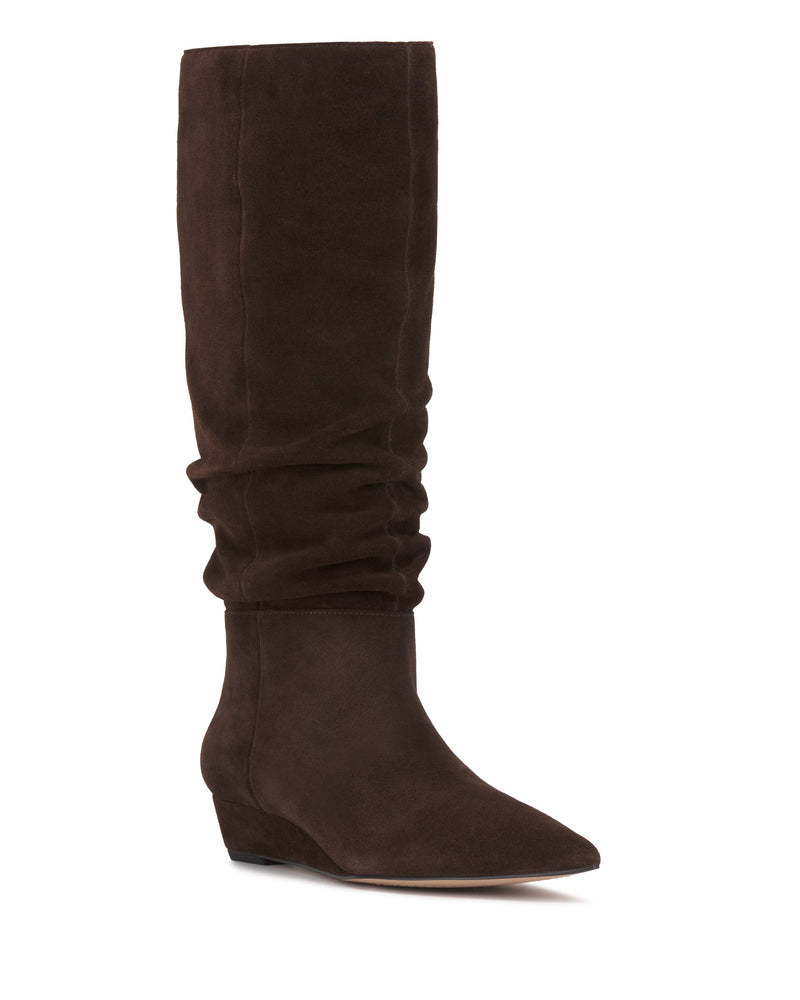 The Vanisa Wide Calf Knee High Boot by Vince Camuto is a tall, brown suede boot featuring a slightly slouched shaft, pointed toe, and low wedge heel, displayed against a white background.
