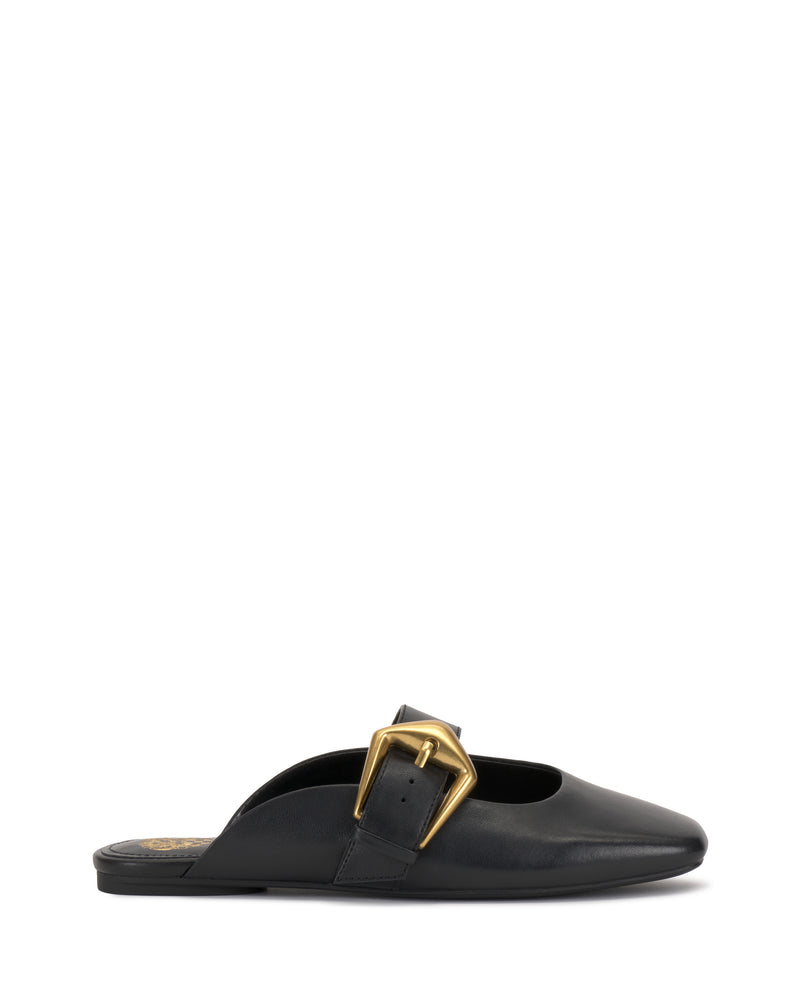 The Vellma Buckle Mule by Vince Camuto is a black leather slip-on with a pointed toe, flat sole, and features a large gold buckle detail on the upper side.