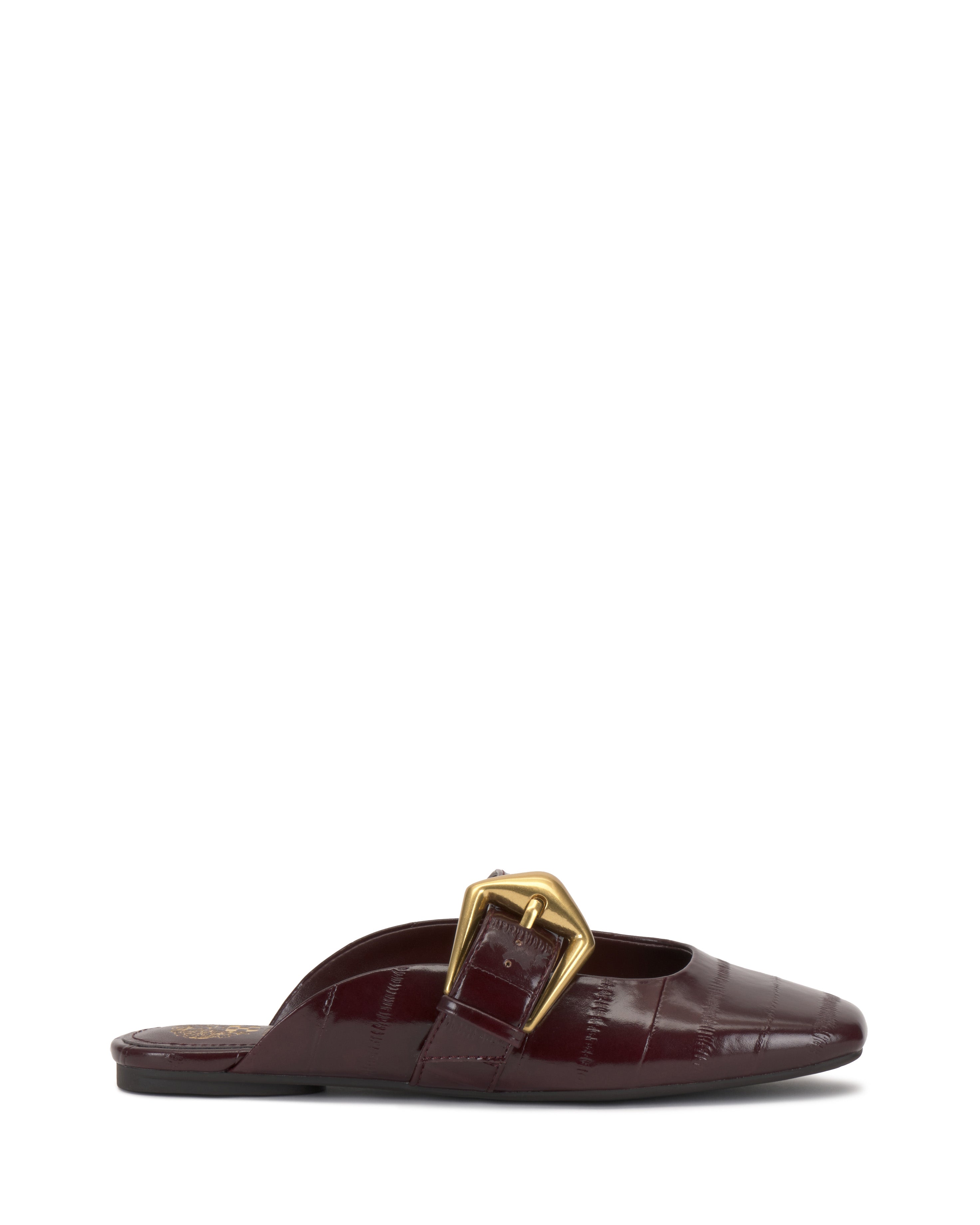 The Vince Camuto Vellma Buckle Mule is a maroon slip-on shoe with a crocodile-pattern texture, pointed toe, flat sole, and a large gold buckle on top.