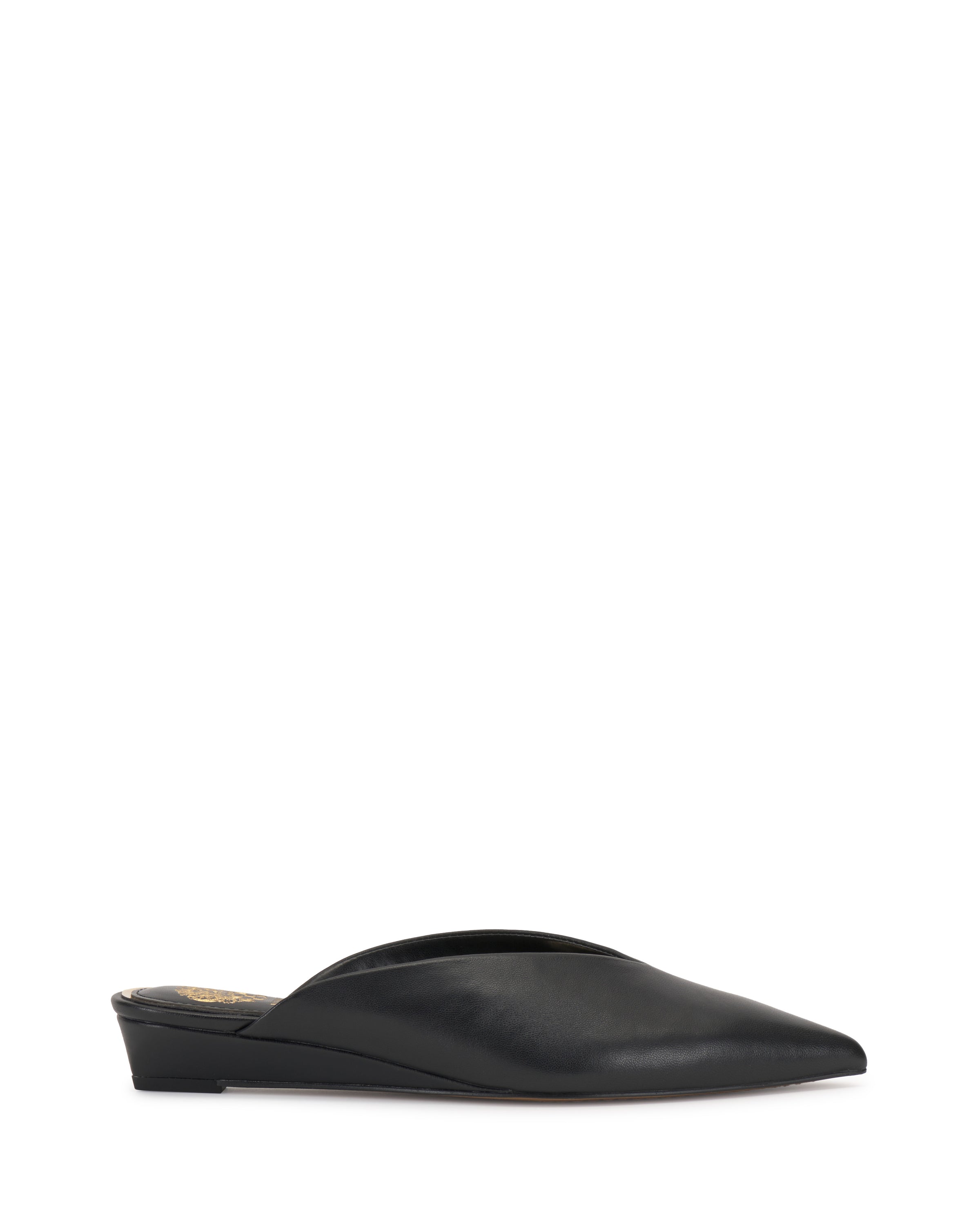 The Vinia Mule by Vince Camuto is a black, pointed-toe shoe with a low wedge heel and sleek, minimalist design, displayed against a plain white background.