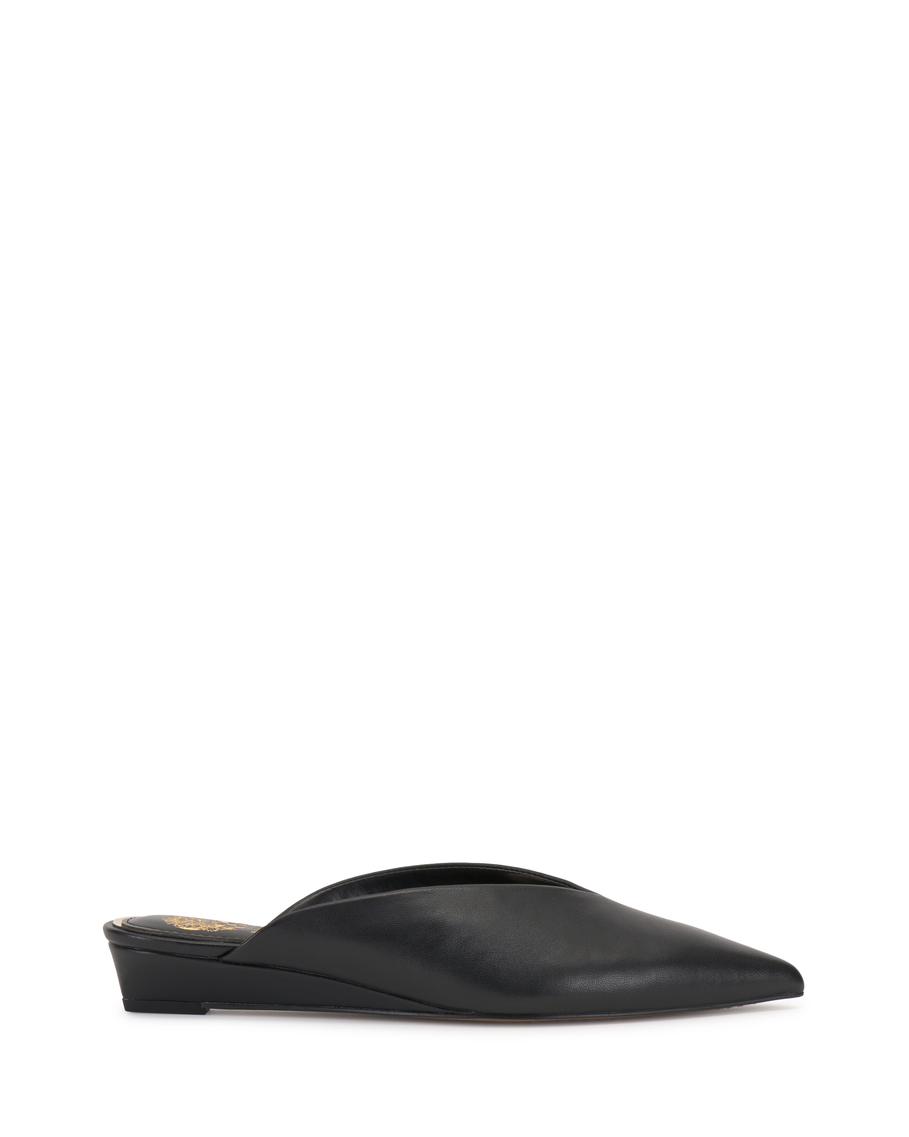 The Vinia Mule by Vince Camuto is a black, pointed-toe shoe with a low wedge heel and sleek, minimalist design, displayed against a plain white background.
