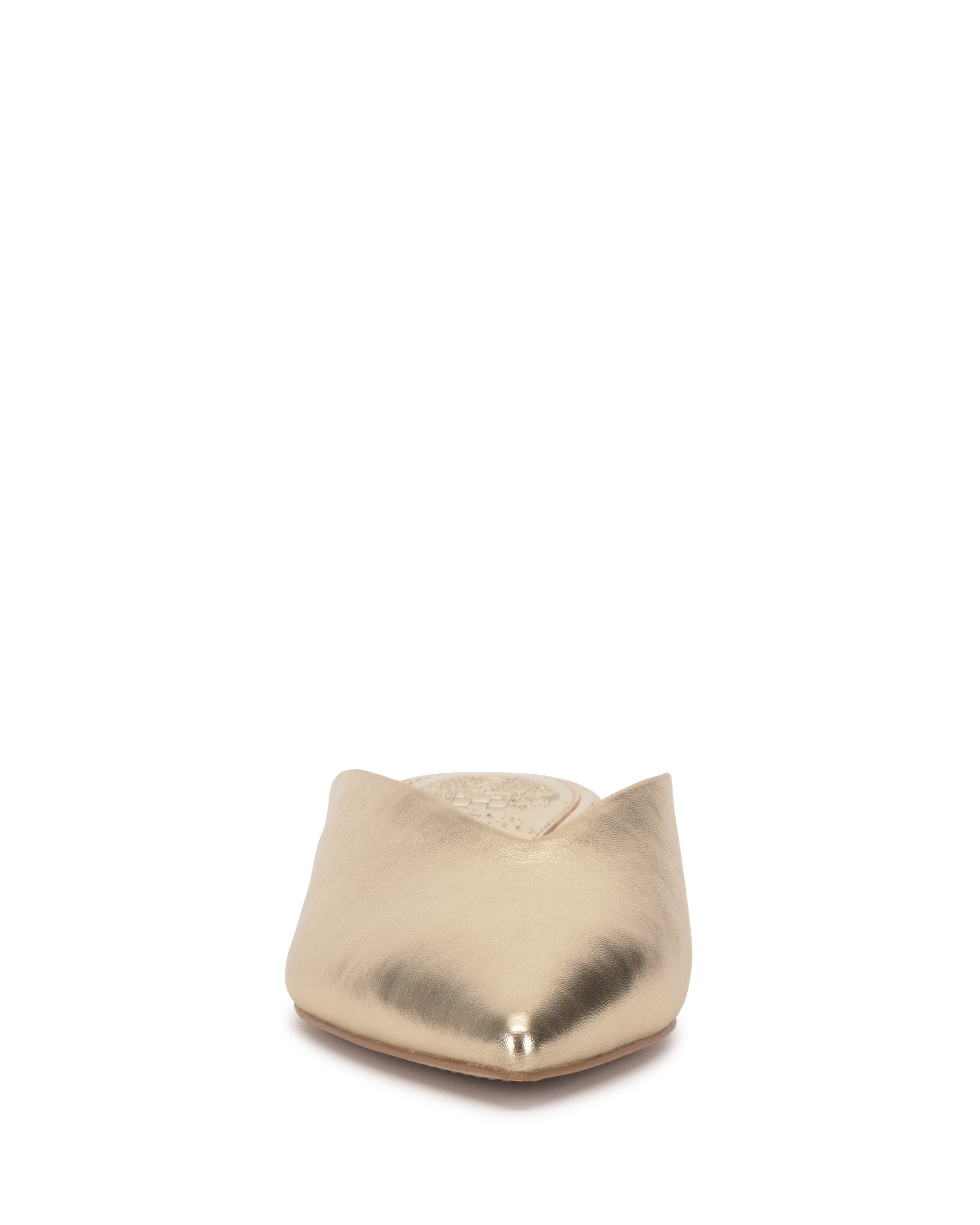 Front view of the Vince Camuto Vinia Mule, a metallic gold backless flat shoe with a pointed toe, shown on a white background.